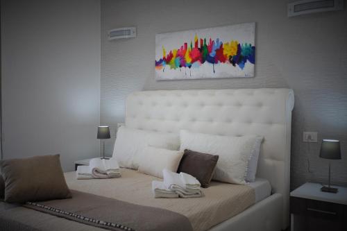 a bedroom with a bed with a white headboard at Central Apartments in Crotone