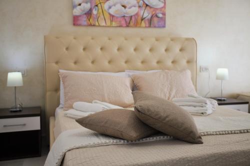 a bedroom with a large bed with pillows and a painting at Central Apartments in Crotone