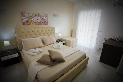 a bedroom with a large bed with towels on it at Central Apartments in Crotone