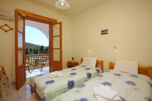 a bedroom with two beds and a balcony at O Ampelonas tou kyr Giorgou in Skopelos Town
