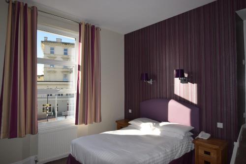 a hotel room with a bed and a window at Riviera Hotel in Torquay