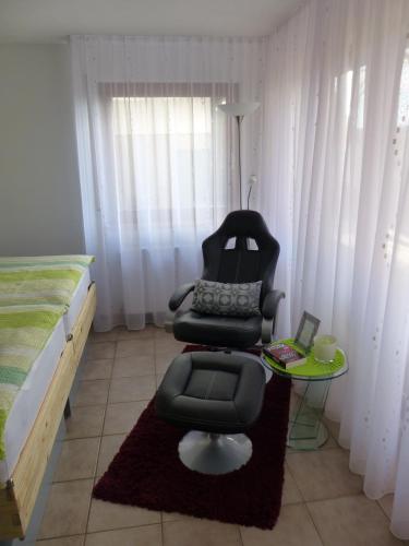a bedroom with a chair and a table and a bed at Ferienwohnung Heimsheim in Heimsheim