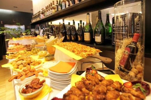 a buffet with lots of food and bottles of wine at Hotel Major in Ronchi dei Legionari