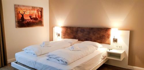 1 dormitorio con 2 camas con sábanas blancas en Ferienquartier Winterberg en Winterberg