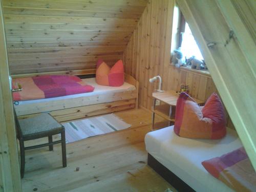 a log cabin bedroom with two beds and a sink at Ferien auf dem Lande in Leopoldshagen