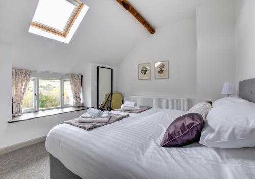 een slaapkamer met een groot wit bed met handdoeken erop bij 2 Bed in Machynlleth oc-bow39 in Darowen