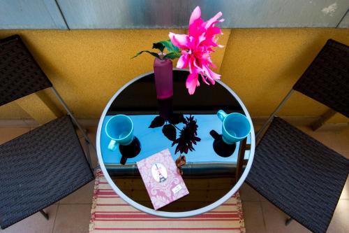 a mirror on a table with a vase with a flower at Grand Budapest Penthouse in Budapest