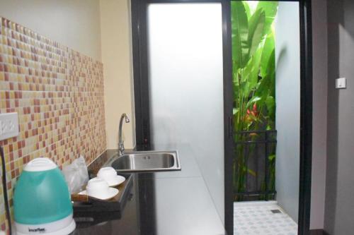 a bathroom with a sink and a fishtank at Isayarada Apartment in Thalang