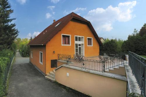 a small orange house with a balcony on a street at Nr 100 Szentendre Hotel Panzio szolgáltatások in Szentendre