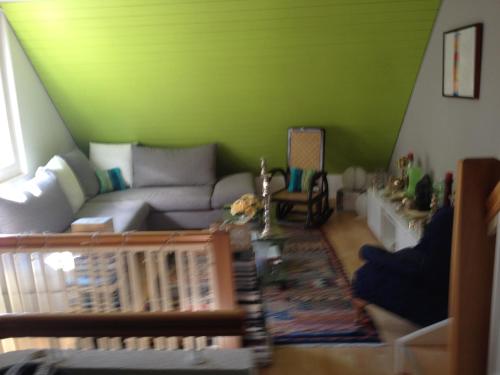 uma sala de estar com um sofá e uma parede verde em Executive suite in Zug Old Town Triplex em Zug