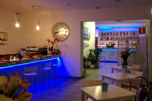 a restaurant with tables and a bar with blue lights at Maree Hotel in Cesenatico
