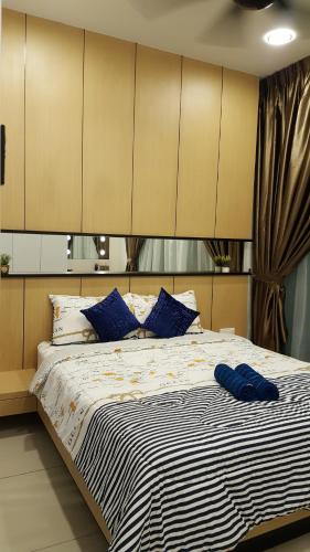 a bedroom with a large bed with blue pillows at Studio Homestay@JB in Johor Bahru