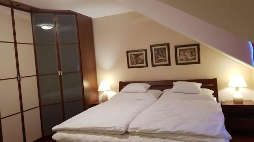 a bedroom with two white beds and two lamps at Mimi Apartman in Balatonalmádi