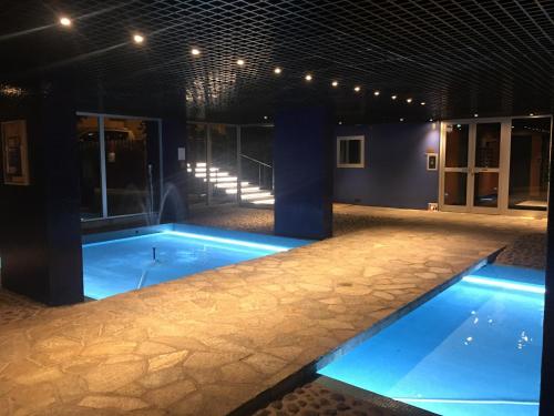 a swimming pool at night with blue lighting at Large studio eiffel tower in Paris