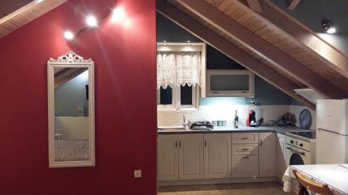 una cucina con parete rossa e specchio di Margarita's Attic-The Suite Loft a Spartià