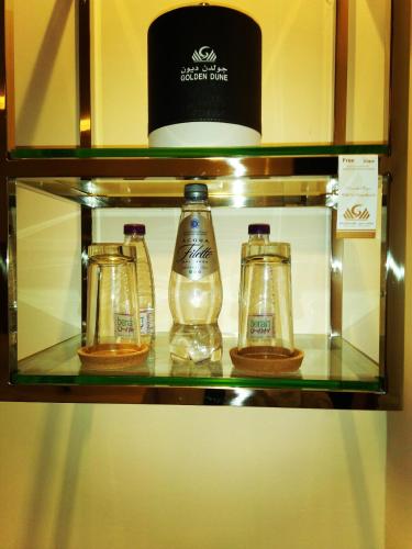 a shelf with three glass bottles on it at Golden dune Hotel Services-Turaif in Ţurayf