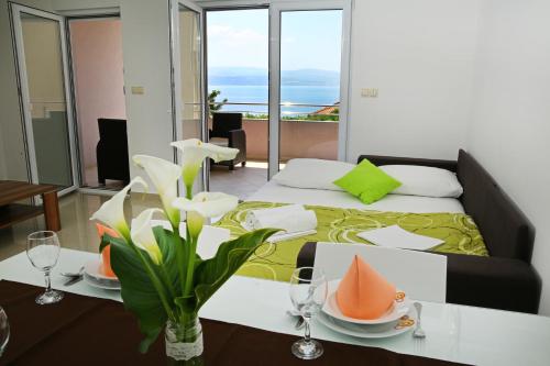una habitación de hotel con una cama y una mesa con platos. en Apartments Nemira Exclusive, en Omiš