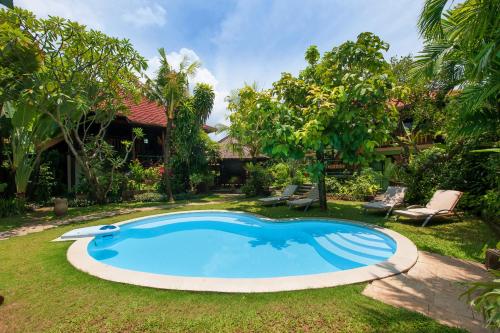 een zwembad in de tuin van een huis bij Pondok Agung Bed & Breakfast in Nusa Dua