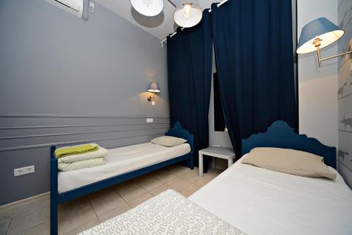 Cette chambre comprend 2 lits et un rideau bleu. dans l'établissement Yum-Yum Hostel, à Moscou