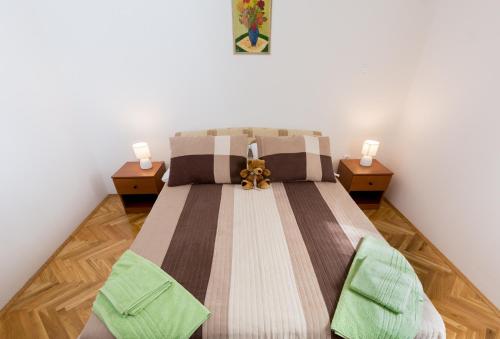 a bedroom with a large bed with two night stands at Breki Apartman in Podstrana