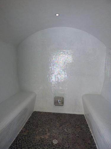 a bathroom with two tubs and a clock on the wall at Mas d'Asvin & Spa in Saint-Christol-lès-Alès