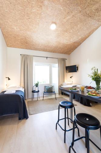 a bedroom with a bed and two stools in a room at Spot Apartments Uusmäki in Espoo