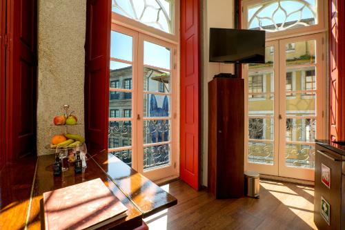 sala de estar con paredes y ventanas de color rojo y TV en Flores Lofts, en Oporto