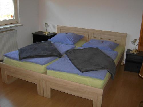 a bedroom with two twin beds with blue pillows at Gasthof Zum Stausee in Engelskirchen