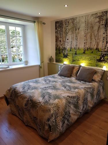 a bed in a bedroom with a large window at Résidence CoatArmor in Tonquédec