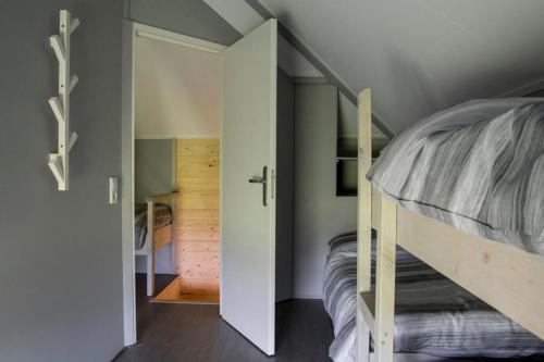 Camping Nieuw Romalo في فورتهاوزن: غرفة نوم صغيرة مع سرير بطابقين وممر