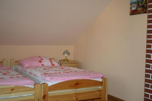 a bedroom with two beds with pink sheets at Gasthof Zum Stausee in Engelskirchen