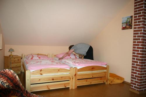 a man is making a bed in a room at Gasthof Zum Stausee in Engelskirchen