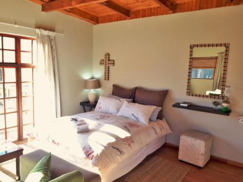 a bedroom with a bed and a cross on the wall at Swallows Nest Self Catering Chalet in Rhodes
