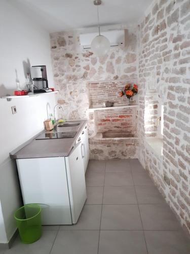 a kitchen with a sink and a brick wall at Old Town Studio in Šibenik