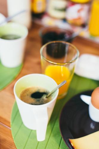 een tafel met een kopje koffie en een glas sinaasappelsap bij B&B Place Jourdan in Brussel