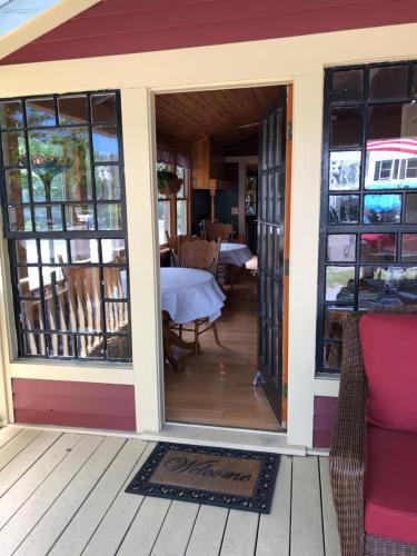 een afgeschermde veranda met een tafel en stoelen bij Central House Inn in Bar Harbor