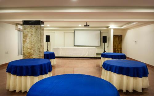 a room with blue and white tables and a screen at Hotel Presidency-Electronic City Phase II in Bengaluru