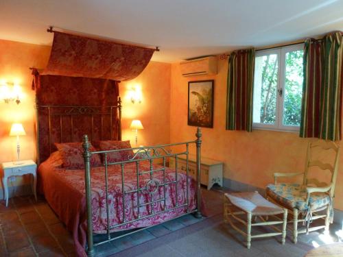 1 dormitorio con 1 cama y 1 silla en Mas de la Chapelle, en Arles
