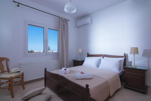 sypialnia z łóżkiem, krzesłem i oknem w obiekcie Casa Di Mario w mieście Kokkini Hani
