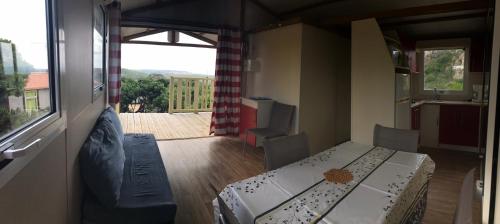 a small room with a table and chairs and a window at Camping Trinité in Bonifacio