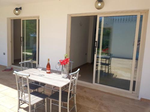 a dining room with a table and chairs and sliding glass doors at Mazzitelli Apartment in Capo Vaticano