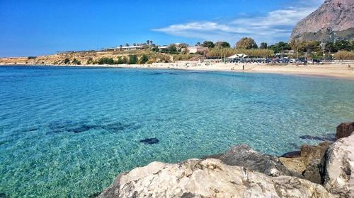 una spiaggia con una grande distesa di acqua e rocce di La Casa del Sole a Cinisi