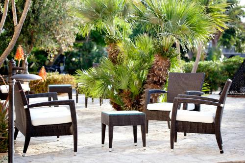 a patio area with chairs, tables and umbrellas at FAVIGNANA HOTEL Concept Holiday in Favignana