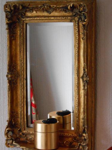 a mirror in a gold frame with two candles in front of it at The Globe Inn in Chagford