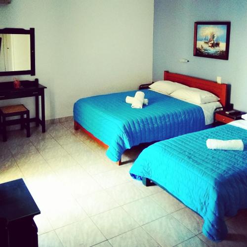 a hotel room with two beds and a desk at Christina Perlia Studios in Poros