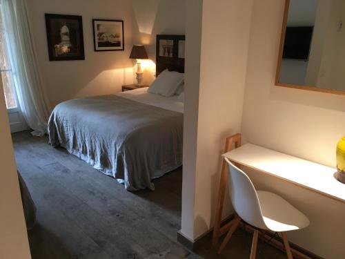 a bedroom with a bed and a desk with a chair at Le Clos des Sept Palmiers in Cavalaire-sur-Mer