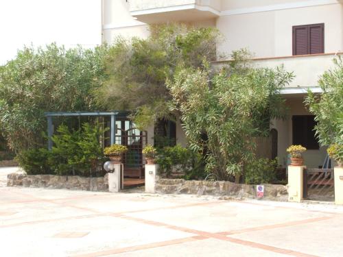 a building with trees in front of it at Una Finestra sul Mare in Calasetta