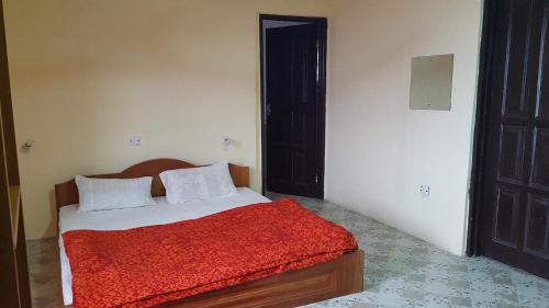 a bedroom with a bed with a red blanket at IS Guest House in Cape Coast