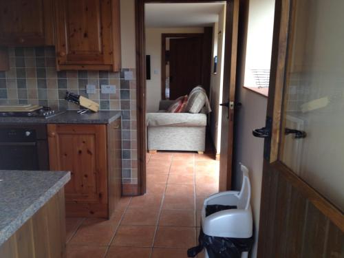 une cuisine avec une porte s'ouvrant sur un salon dans l'établissement Stable Cottage, à Scarborough