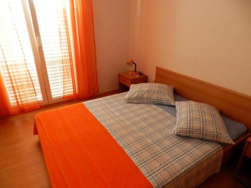 a bedroom with a bed with two pillows and a window at Apartments Senny in Orebić